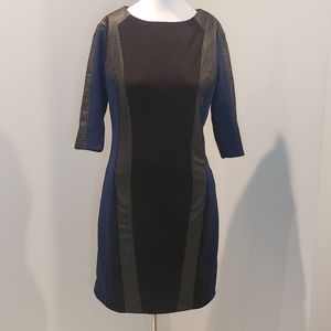 Black and blue dress with strips of leather going down side of dress